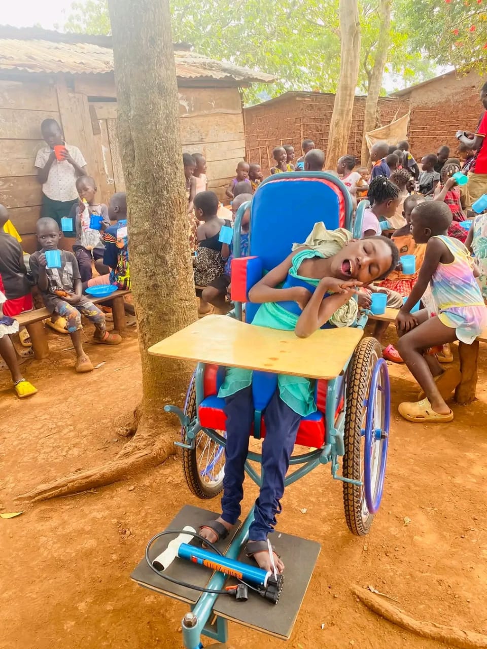 A child in a wheelchair joins other children at a community gathering